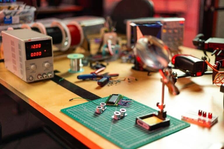 Electronics workbench with tools, components, and equipment, including a power supply and prototyping materials.